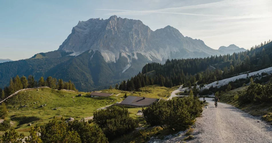 Die Zugspitze, Almwiesen und eine Hütte | © Tiroler Zugspitz Arena/ Sam Oetiker