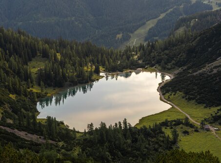 Der glasklare Seebensee von oben, umringt von Wiesen, Bäumen und Felsen | © Tiroler Zugspitz Arena/Sam Oetiker