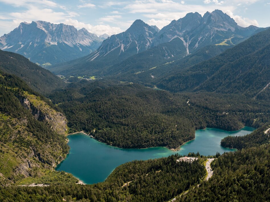 Eine Drohnenaufnahme eines türkisfarbenen Bergsees vor imposanter Bergkulissse | © Tiroler Zugspitz Arena/Sam Oetiker