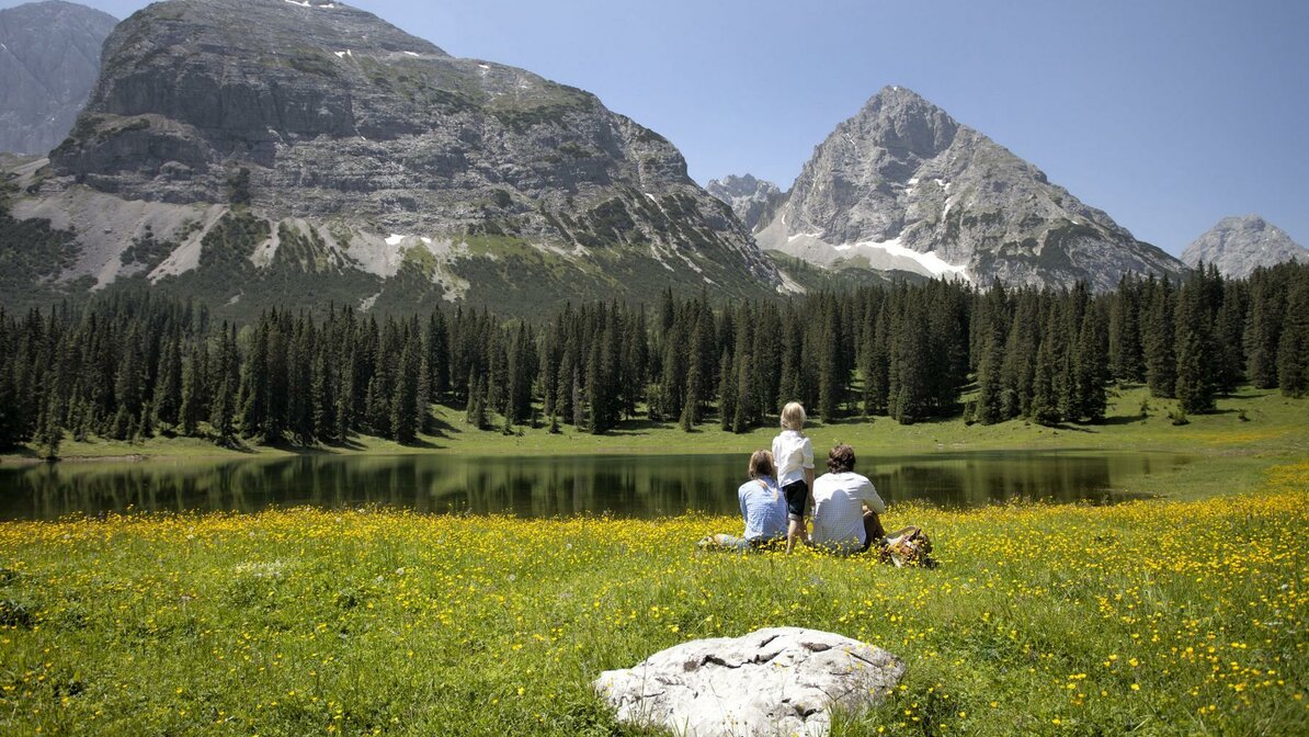 A family on a blooming mountain meadow | © Uli Wiesmeier