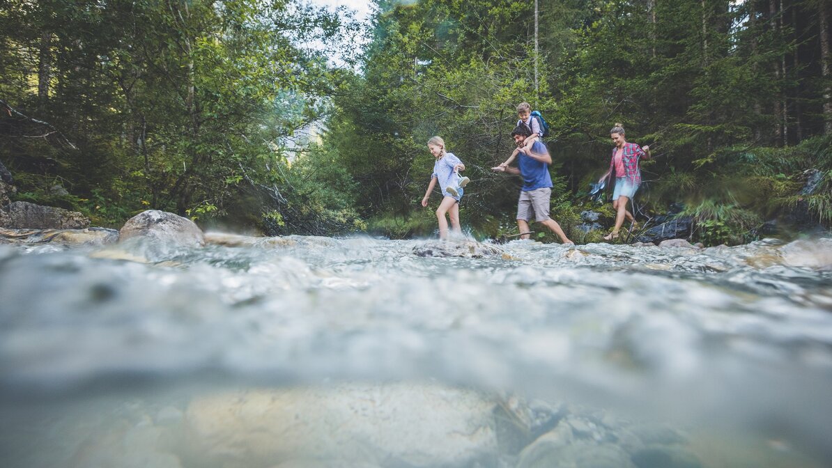 A family walks through a small stream | © Tiroler Zugspitz Arena/C. Jorda