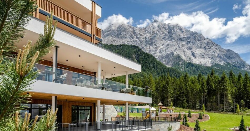 ein modernes Hotel mit der Zugspitze im Hintergrund