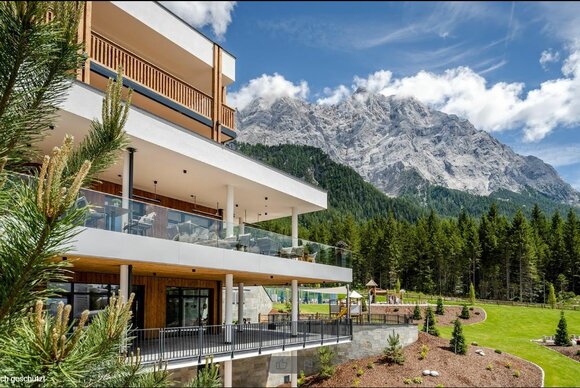 ein modernes Hotel mit der Zugspitze im Hintergrund