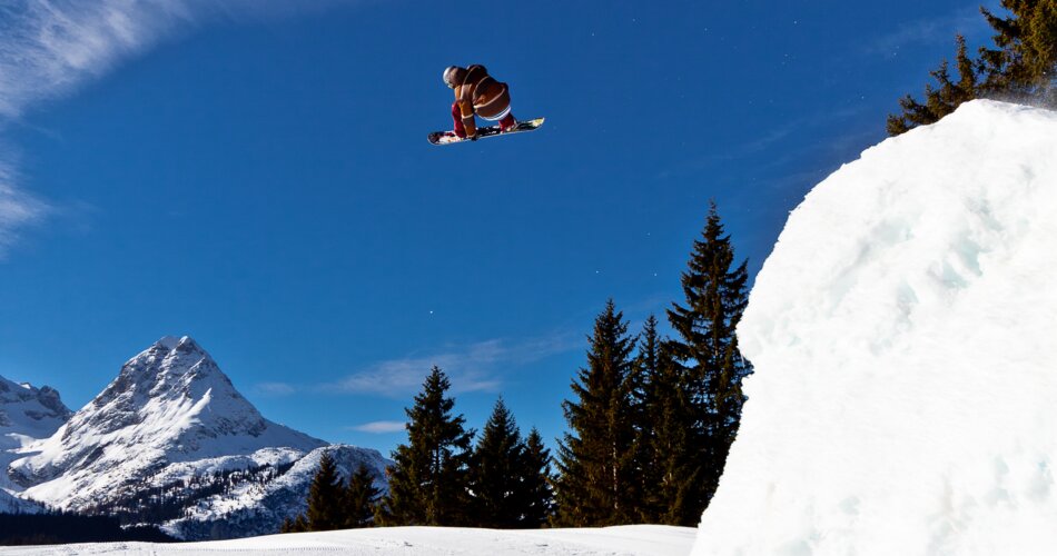 Ein Snowboarder springt über eine Schanze