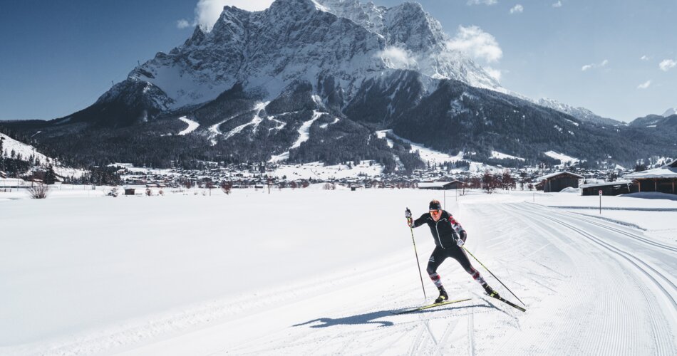 A cross-country skier on a trail, with the Zugspitze in the background | © Tiroler Zugspitz Arena/ Roast Media