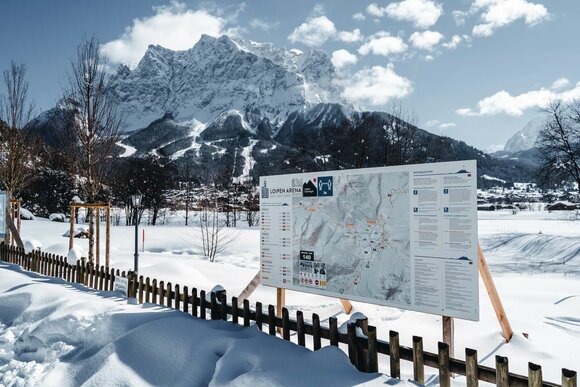 Sign with explanations, Zugspitze and snow in the background | © Tiroler Zugspitz Arena/ Roast Media