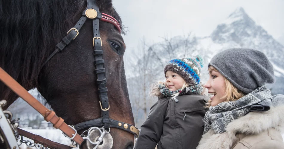 Frau mit Kleinkind neben einem Pferd. | © Tiroler Zugspitz Arena/C. Jorda