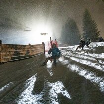 Eine Familie beim Nachtrodeln  | © Tiroler Zugspitz Arena/ Valentin Schennach