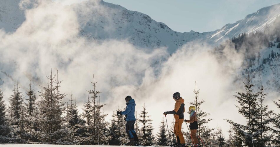 Mehrere Skifahrer stehen auf einer frisch präparierten Piste, im Hintergrund eine verschneite Winterlandschaft und Bergpanorama | © Tiroler Zugspitz Arena/Sam Oetiker