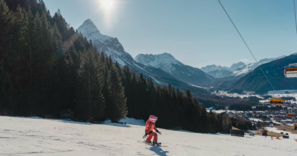 A small child skiing, in the background mountain panorama in sunny weather | © Tiroler Zugspitz Arena/Sam Oetiker