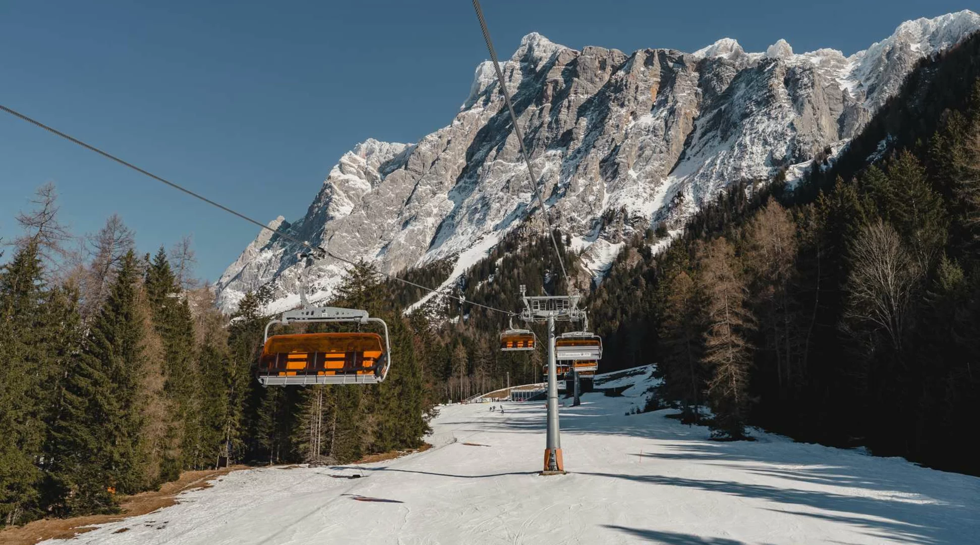 Ehrwalder Wettersteinbahnen | © Tiroler Zugspitz Arena/Sam Oetiker Ein Sessellift, im Hintergrund das imposante Bergmassiv der Zugspitze | © Tiroler Zugspitz Arena/Sam Oetiker