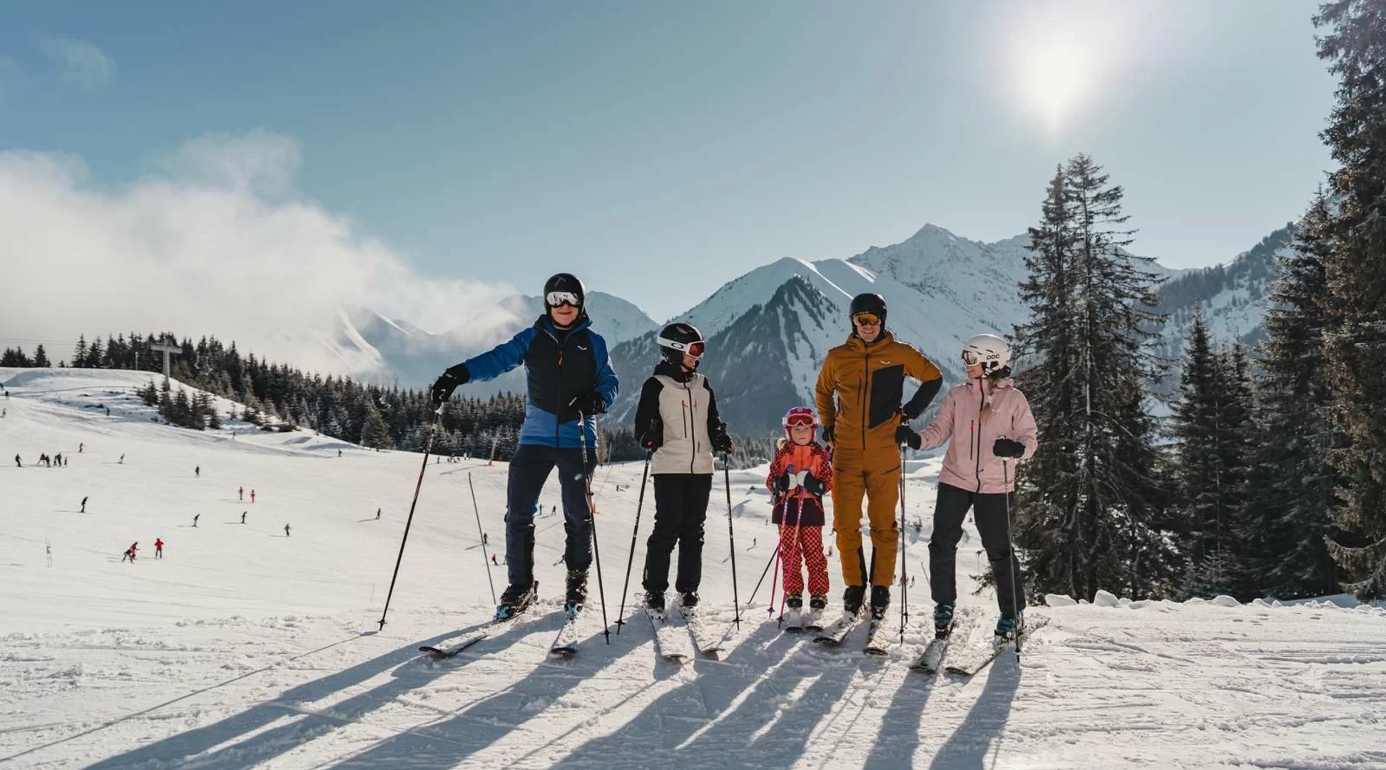 Skifahren Berwang-Bichlbach | © Tiroler Zugspitz Arena/Oetiker Sam Eine Familie mit Freunden auf der Skipiste im Hintergrund winterliches Bergpanorama | © Tiroler Zugspitz Arena/Oetiker Sam