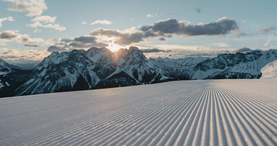 A freshly groomed slope with a wintry mountain panorama in the background | © Tiroler Zugspitz Arena/Sam Oetiker