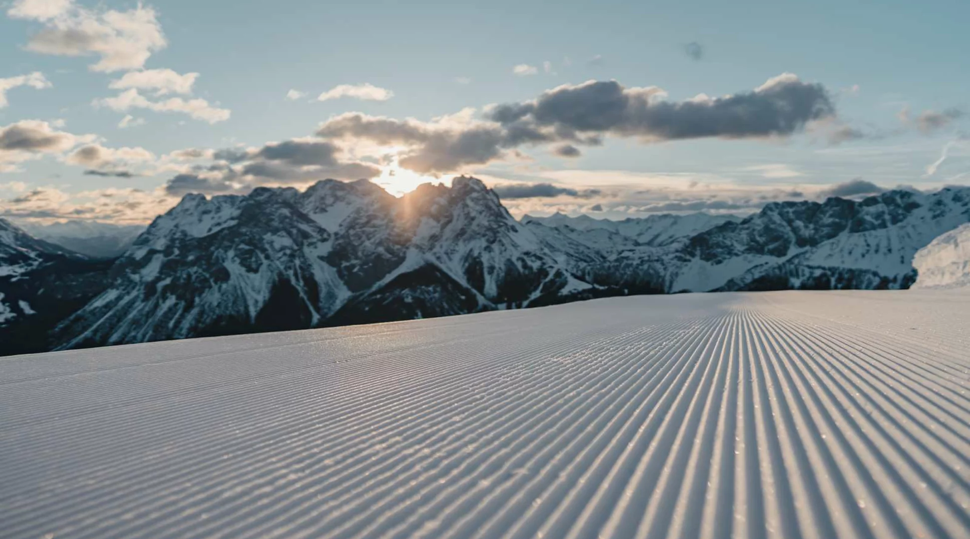 Skifahren am Grubigstein | © Tiroler Zugspitz Arena/Sam Oetiker Eine frisch präparierte Piste, im Hintergrund winterliches Bergpanorama | © Tiroler Zugspitz Arena/Sam Oetiker