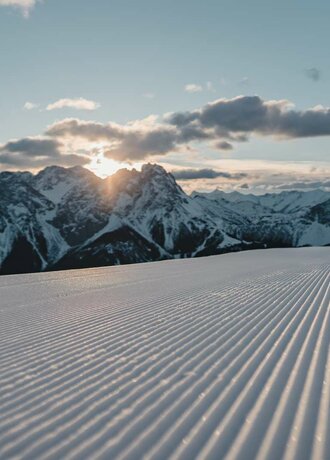 Eine frisch präparierte Piste, im Hintergrund winterliches Bergpanorama | © Tiroler Zugspitz Arena/Sam Oetiker