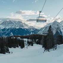 Ein Sessellift über einer frisch präparierten Piste, im Hintergrund Bergpanorama mit der Zugspitze | © Tiroler Zugspitz Arena/Sam Oetiker
