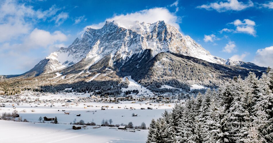 Das beeindruckende Felsmassiv der winterlichen Zugspitze vor blauem Himmel.  | © Tiroler Zugspitz Arena/ Valentin Schennach