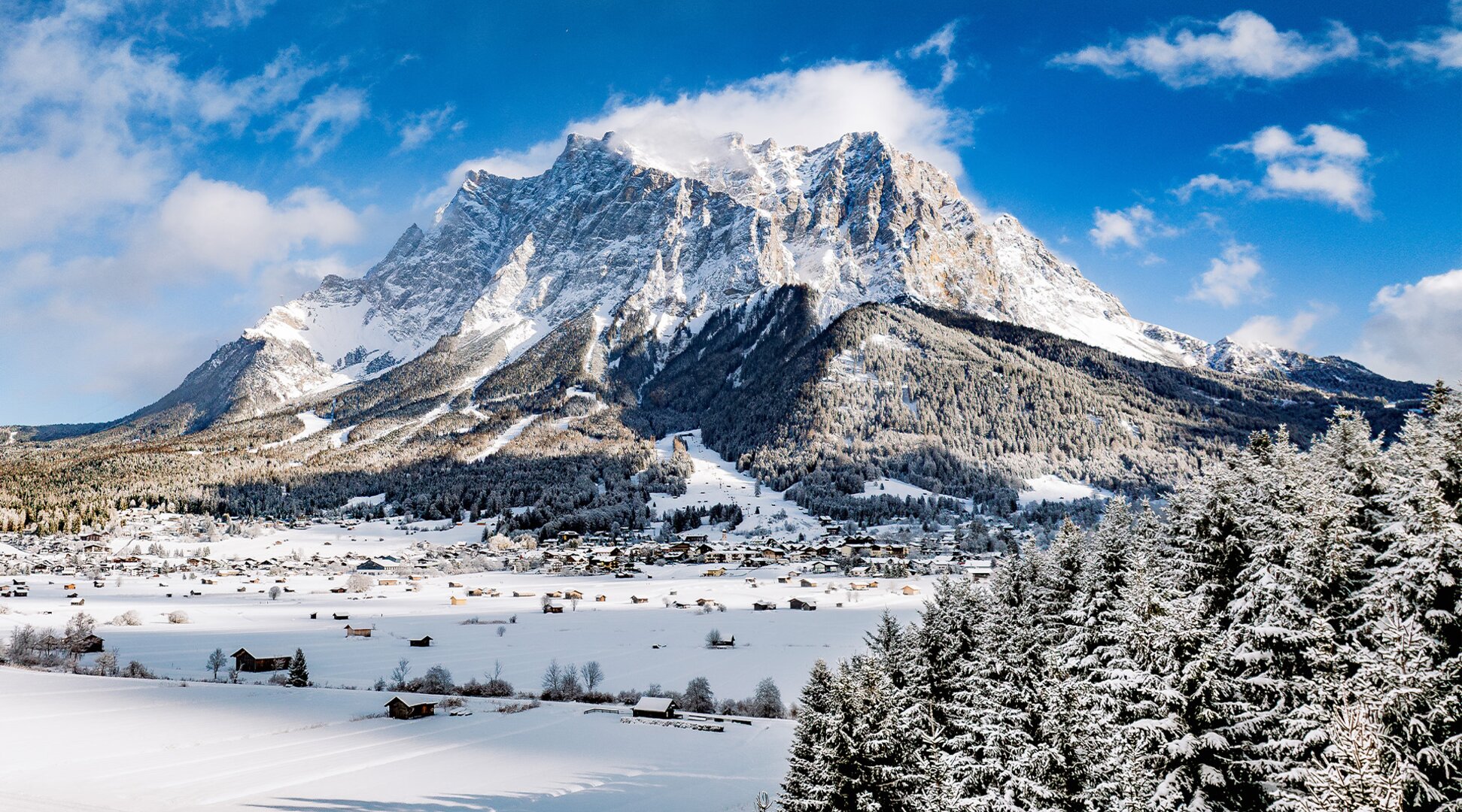 Das beeindruckende Felsmassiv der winterlichen Zugspitze vor blauem Himmel.  | © Tiroler Zugspitz Arena/ Valentin Schennach