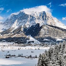 The impressive rock massif of the Zugspitze in winter against a blue sky.  | © Tiroler Zugspitz Arena/ Valentin Schennach