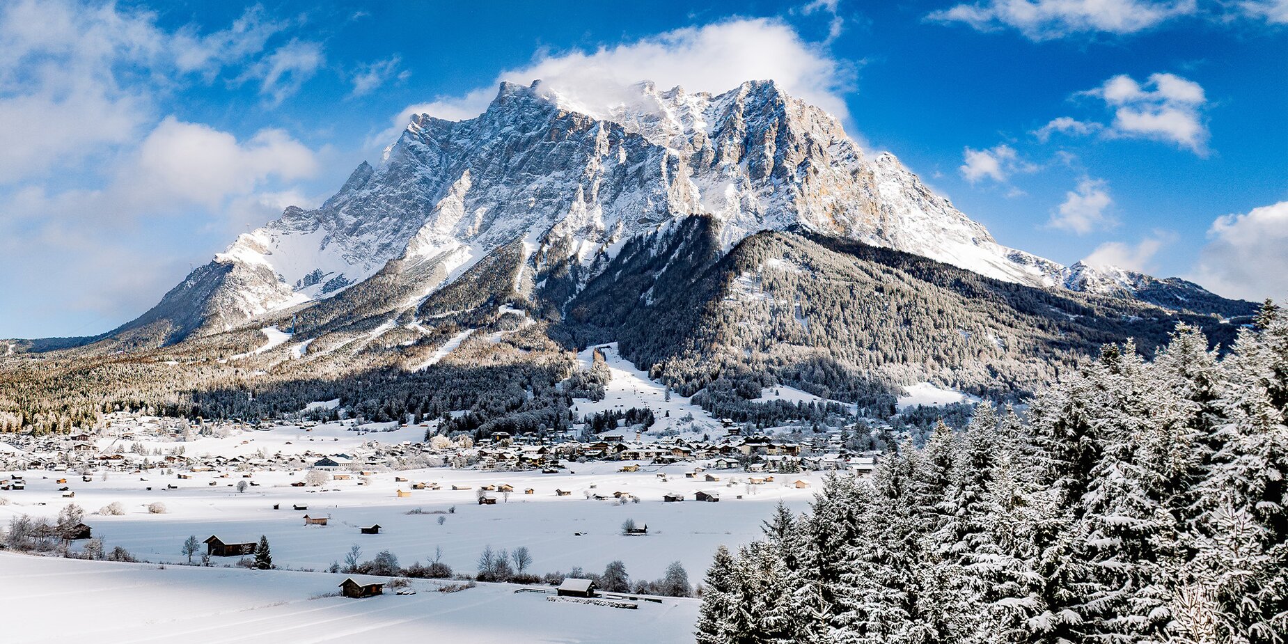 The impressive rock massif of the Zugspitze in winter against a blue sky.  | © Tiroler Zugspitz Arena/ Valentin Schennach
