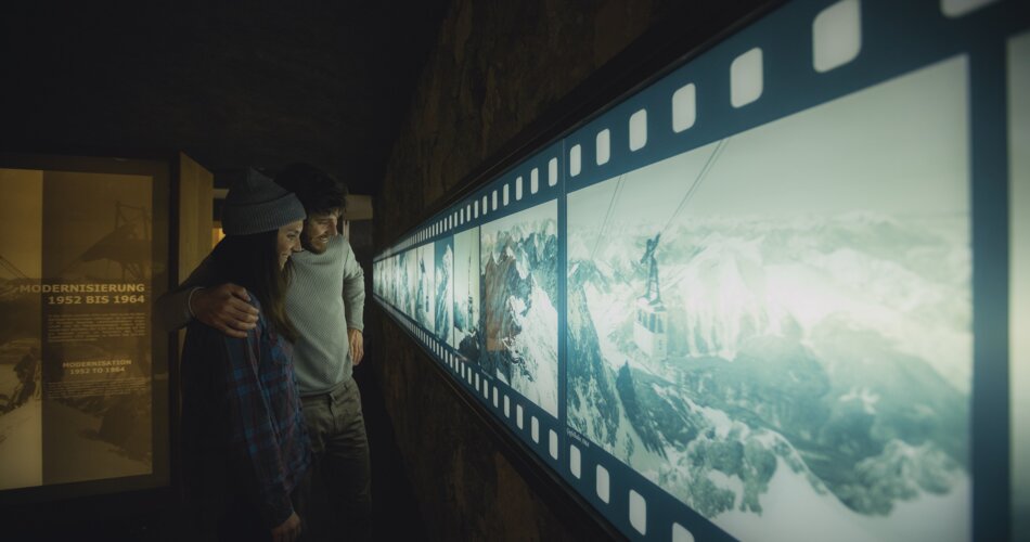 A couple reading information about the history of the cable car | © Tiroler Zugspitz Arena/ Christoph Jorda