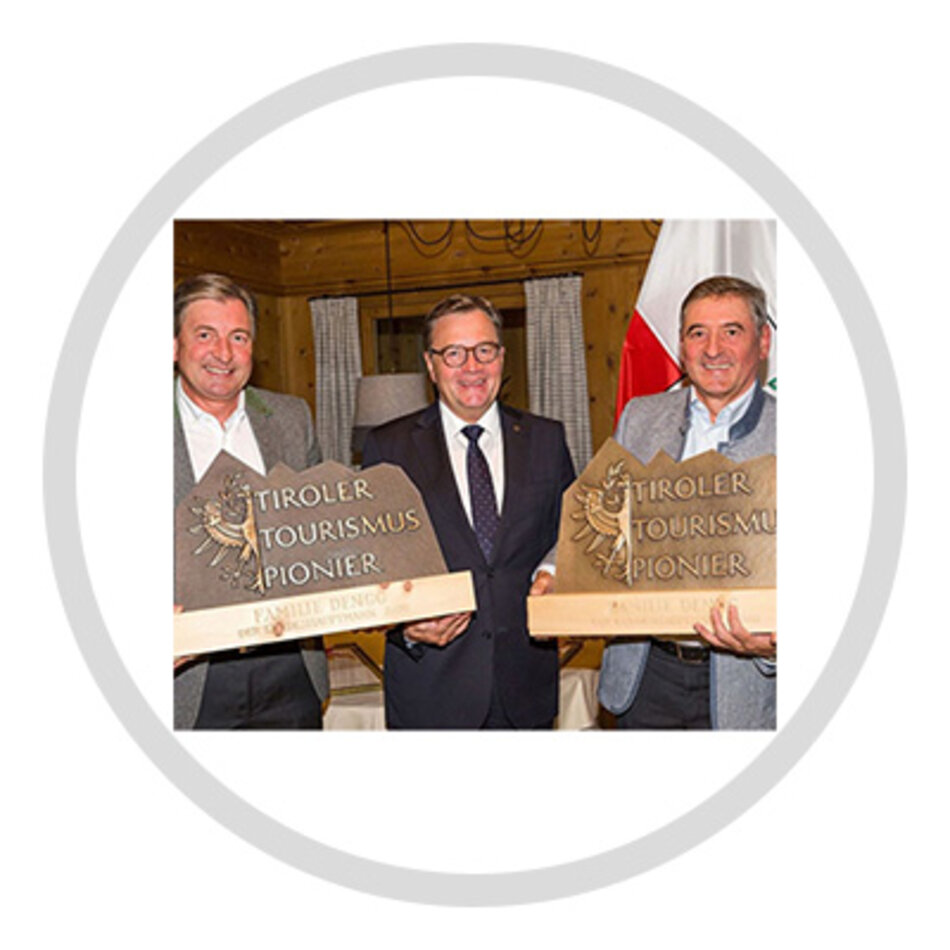 Three men, the two on the left and right are holding the Tyrolean Tourism Pioneer award in their hands | © Tiroler Zugspitzbahn