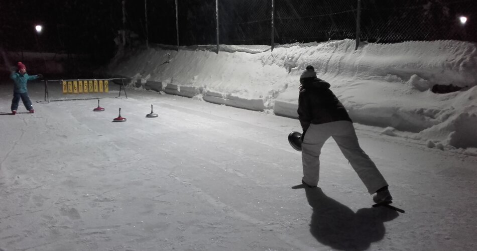 Eislaufplatz mit Tor, im Hintergrund einige Menschen die mitspielen. Eisstockschießen ist vom Bewegungsablauf ähnlich wie Bowling. | © (C)ThomasKätzler