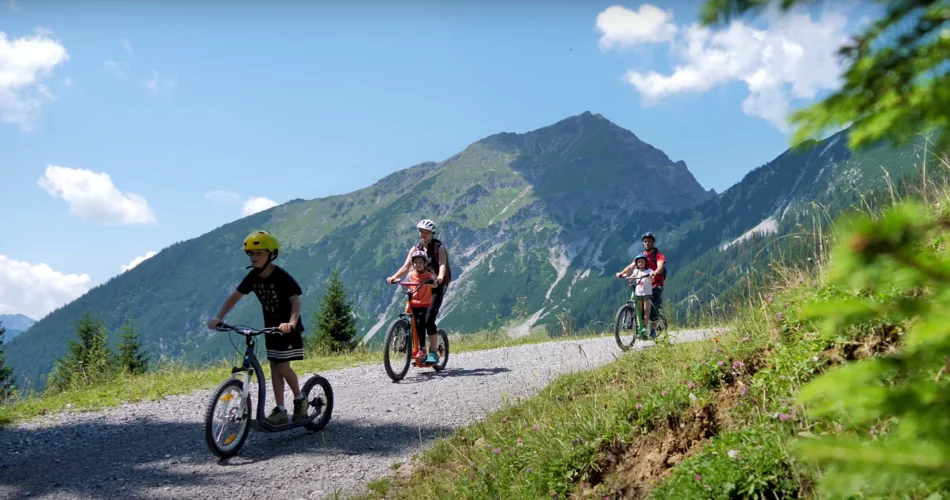 Familie fährt auf großen Bergrollern einen Wald- und Wiesenweg talwärts | © Tiroler Zugspitz Arena